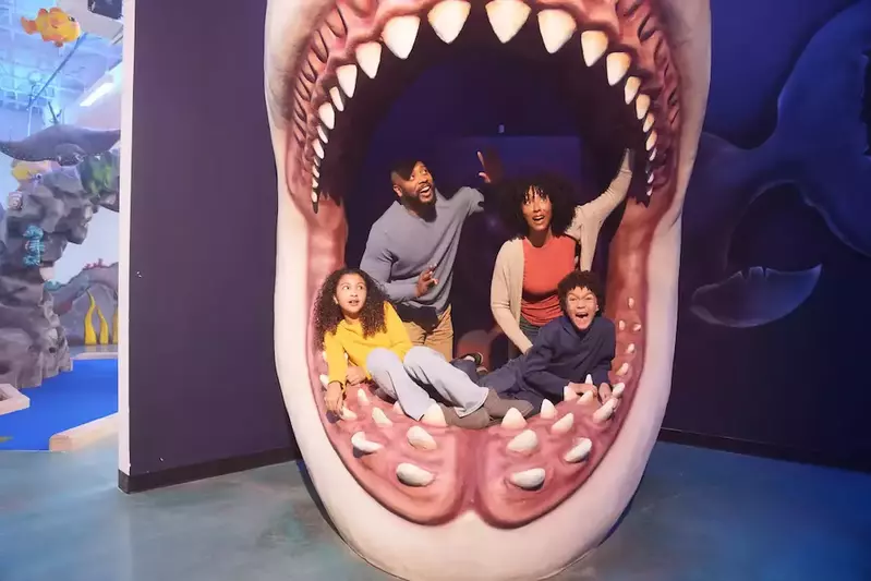 family in shark mouth at attraction